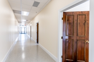 white hallway with natural light and wooden doors
