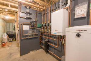 electrical wall with copper colored pipes basement