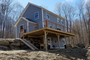 blue home with deck under construction