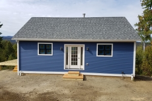 dark blue home in sunshine with white trim