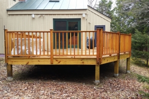 wooden elevated deck with wood railing