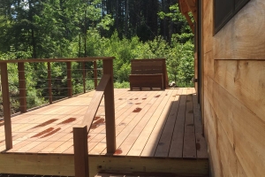 wooden deck with wood steps and trees in background